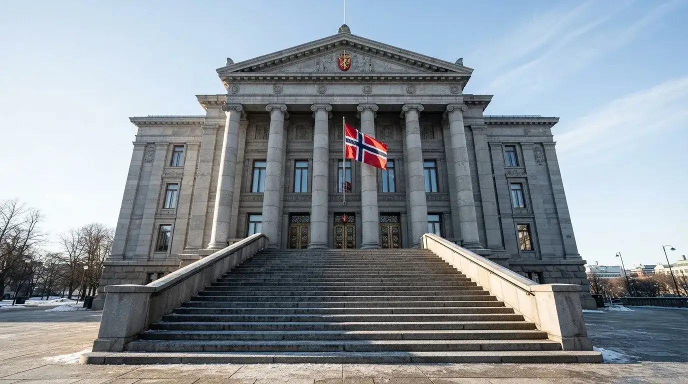 Bred trapp opp til en stor offentlig bygning i grå stein med et norsk flagg, klar vinterdag